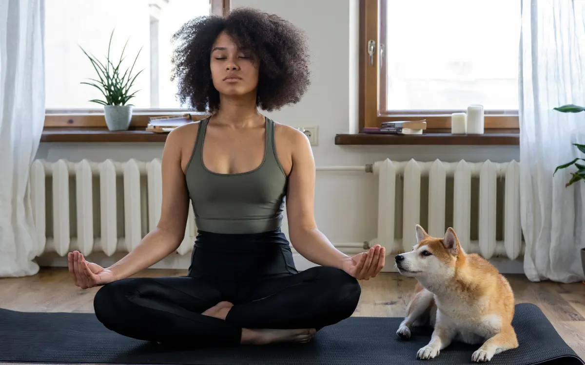 Corpo e Mente: Corpo e Mente: Equilíbrio Saudável -Mulher sentada numa sala meditando com um cachorro ao lado