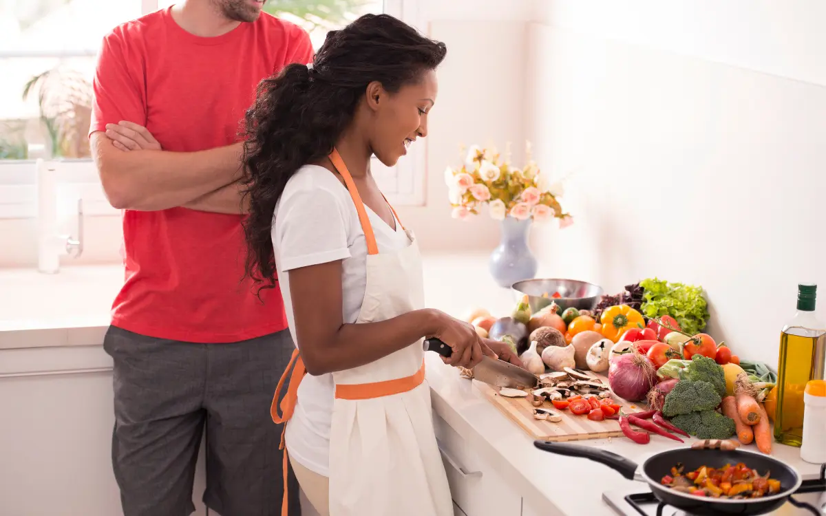 Comida Saudável: Um Convite Para Amar e Cuidar do seu Corpo - Homem e mulher cozinhando com alimentos saudáveis.