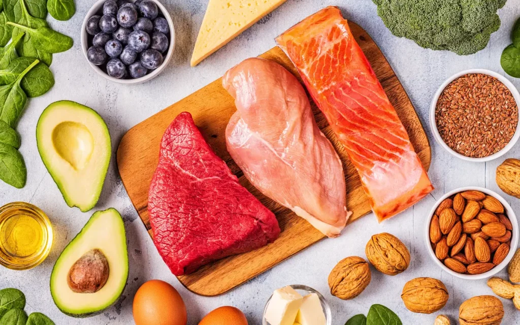 Dieta Cetogênica Mais Saúde Para o seu Dia a Dia - Mesa com carde de boi, frango e peixe, com legumes, frutas, oleosas, queijos e verduras.