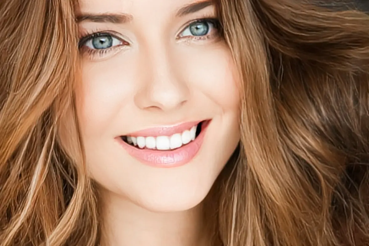 Clareamento Dental Caseiro Dicas e Cuidados - Mulher loira sorrindo com dentes brancos.
