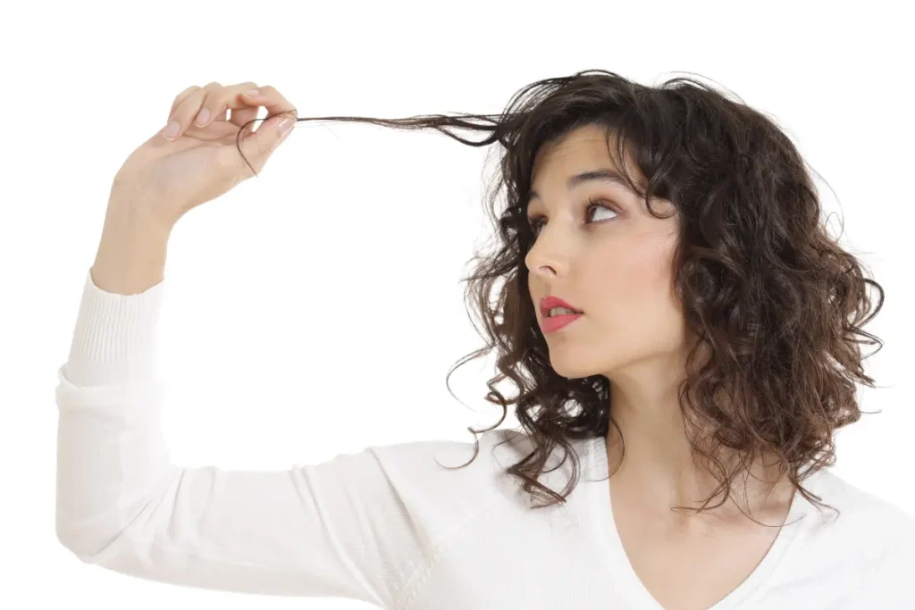 Mulher observando uma mecha do seu cabelo