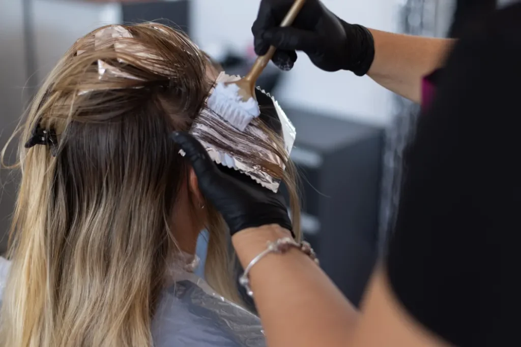 Cabeleireira pintando o cabelo de uma cliente