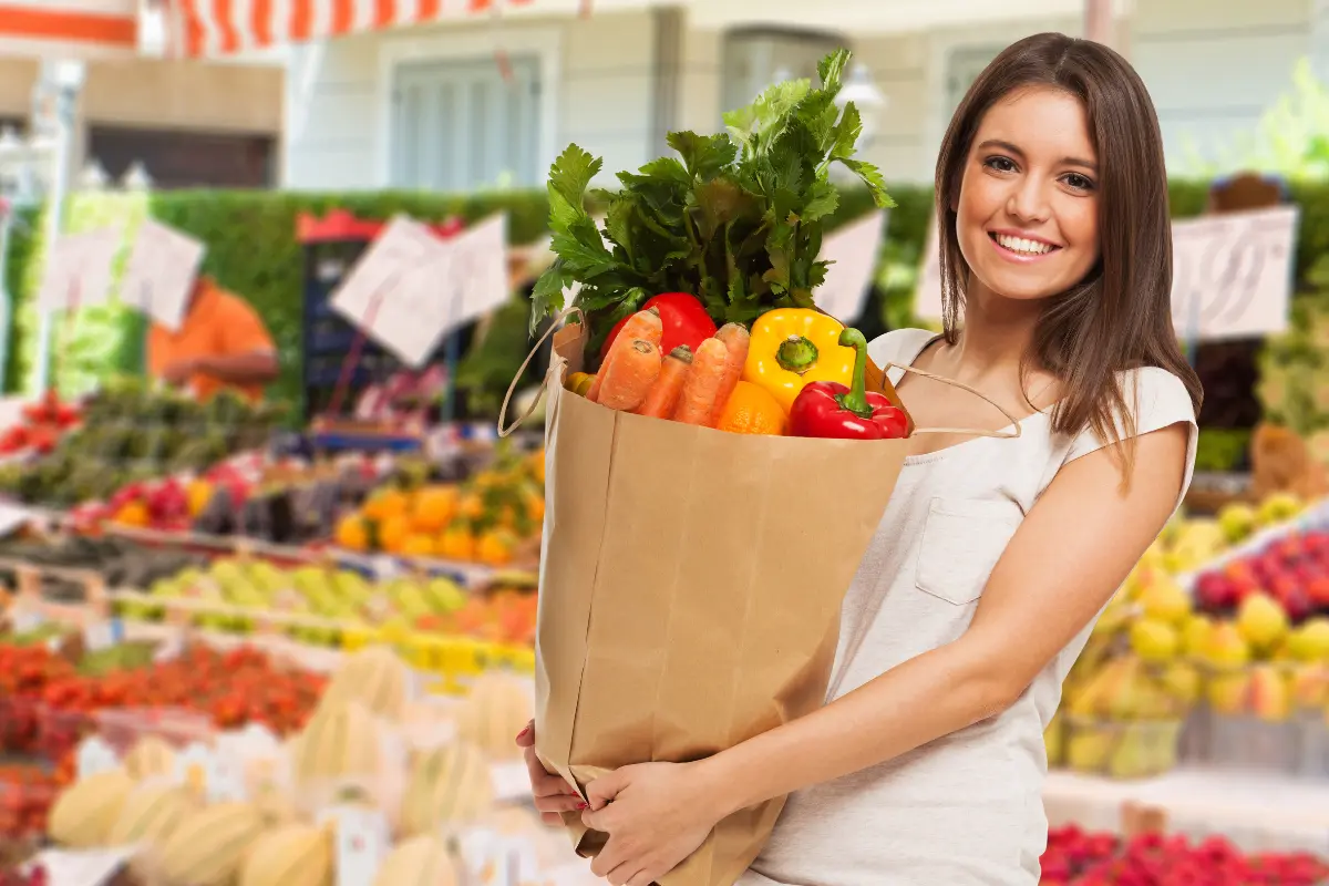 Legumes Mais Saúde no seu Prato - Mulher no supermercado com uma sacola de compras de legumes e verduras