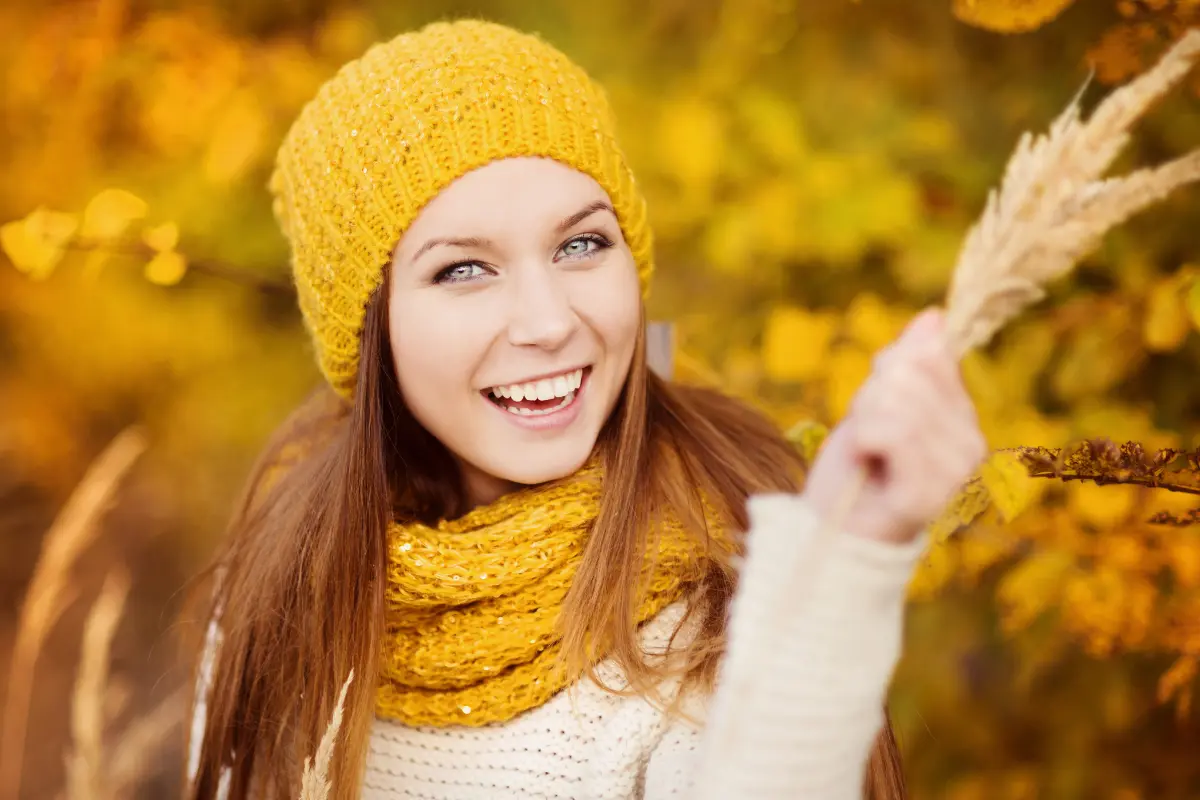 9 Dicas de Cuidados com os cabelos durante o outono/inverno - Mulher agasalhada com blusa de frio, touca a cachecol