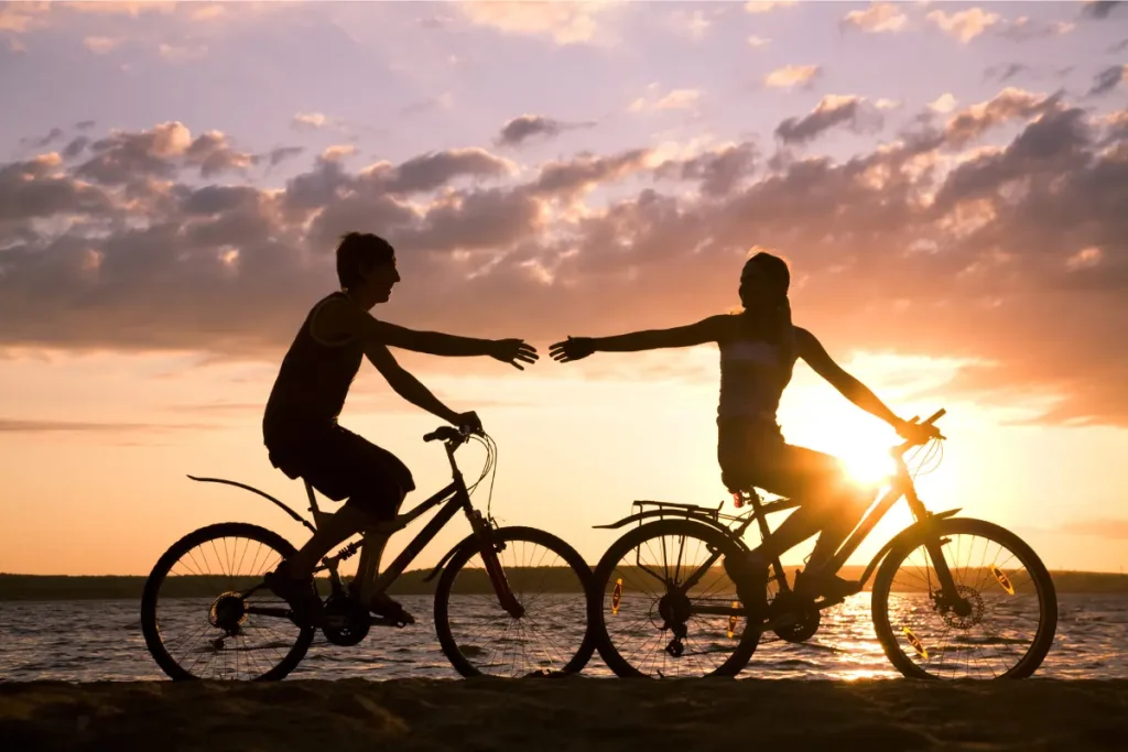 Duas pessoas felizes andando de bicicleta