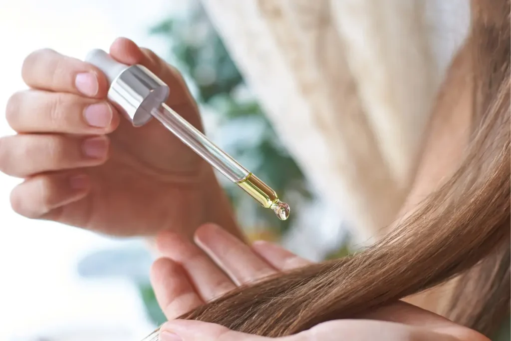 Mulher aplicando óleo no cabelo