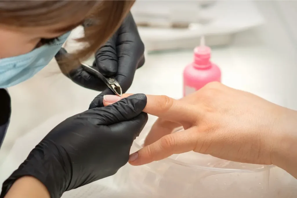 Manicure tirando as cutículas da mão da cliente