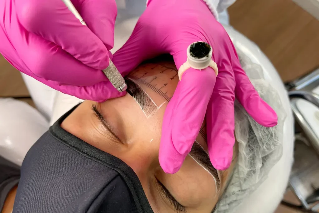 Microblading Descubra os Cuidados Antes e Depois do Procedimento - profissional fazendo o procedimento microblading na sobrancelha da cliente