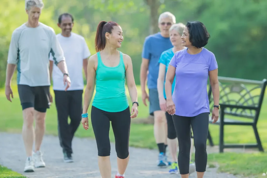 Os Benefícios da Caminhada 12 Razões Para Começar a Caminhar Hoje - Homens e mulheres fazendo caminhada