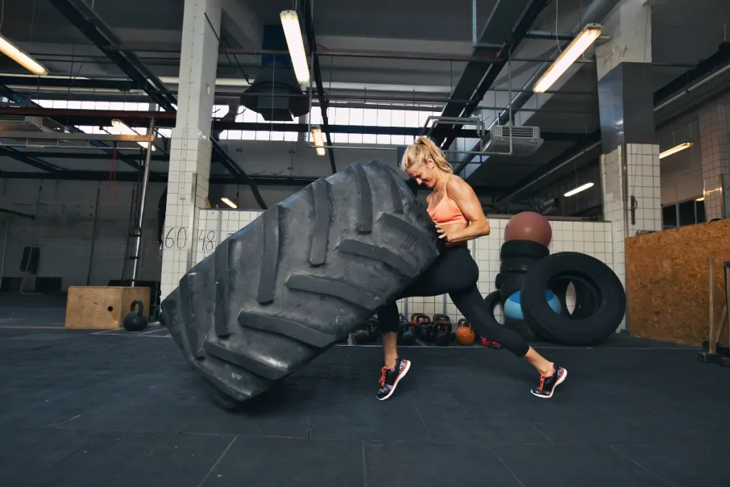 Mulher se exercitando com o pneu trator no CrossFit