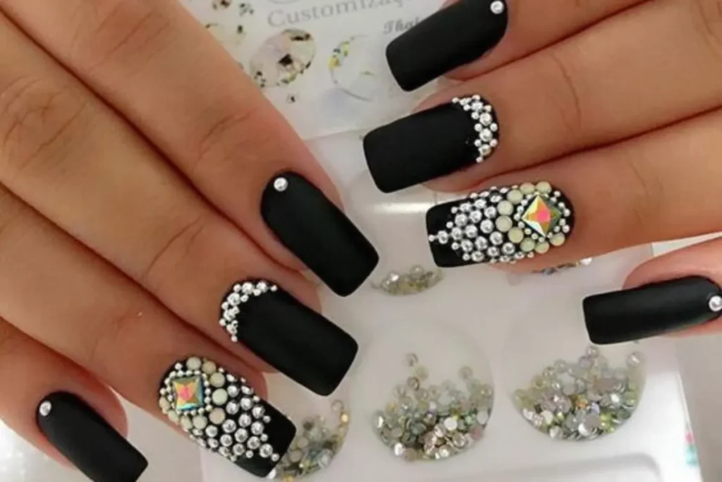 Unhas pretas decoradas com pedrarias