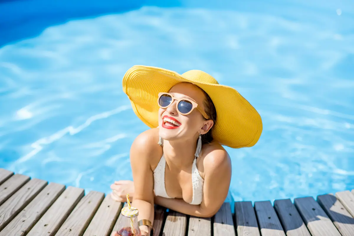 Cabelos Saudáveis 8 Dicas de Cuidados Nesse Verão - Mulher sorrindo na beira da piscina