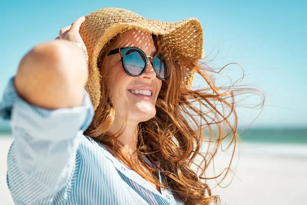 Mulher na praia usando um chapéu