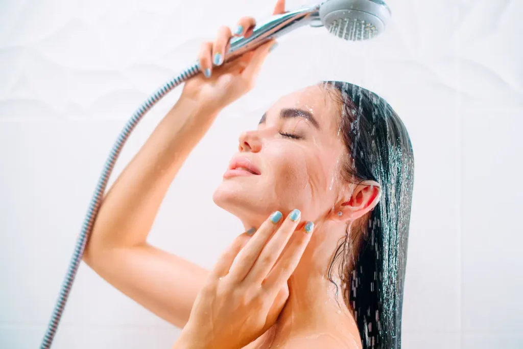 Mulher tomando banho e lavando a cabeça