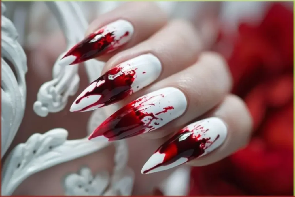 Unhas brancas decoradas com mancha de sangue