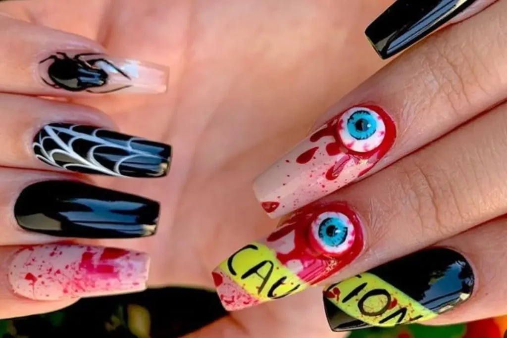 Unhas decoradas com olhos, sangue e teia de aranha