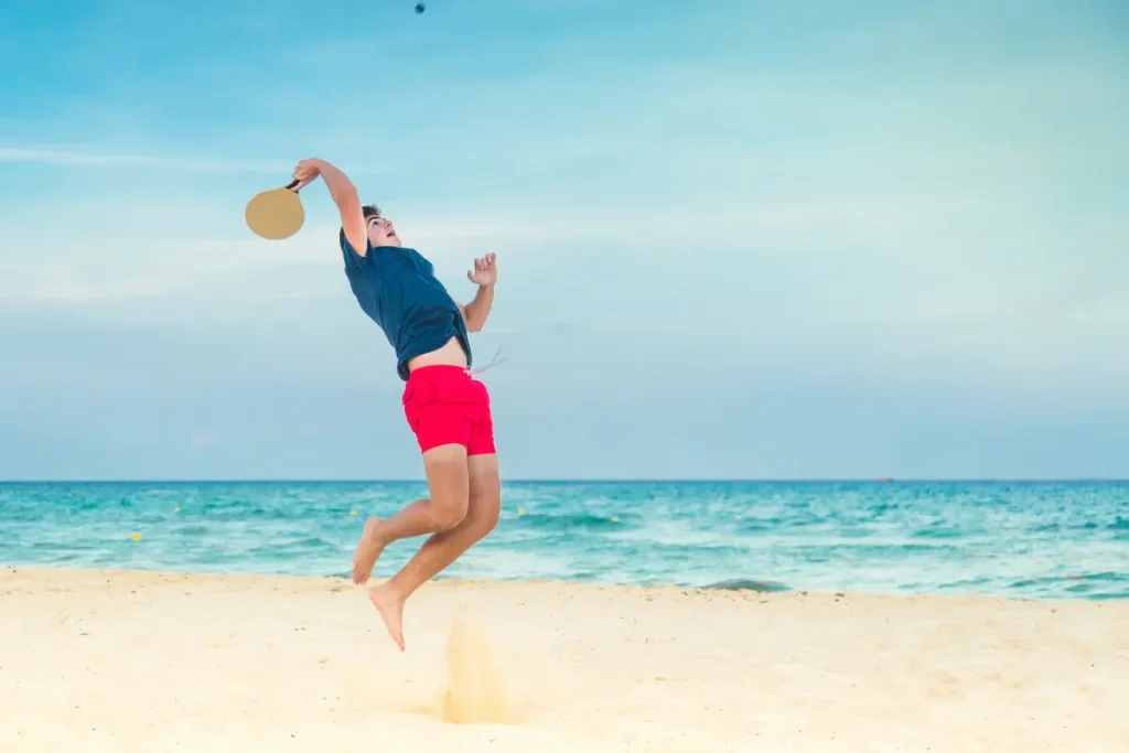 Homem jogando Beach Tennis na praia