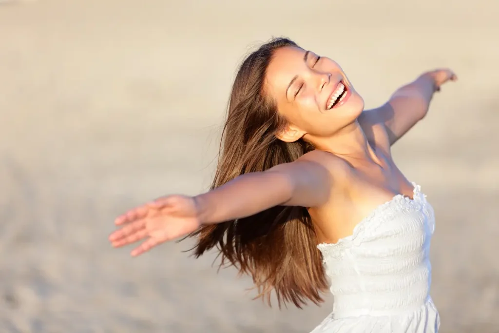 Mulher feliz, sorrindo com os braços abertos