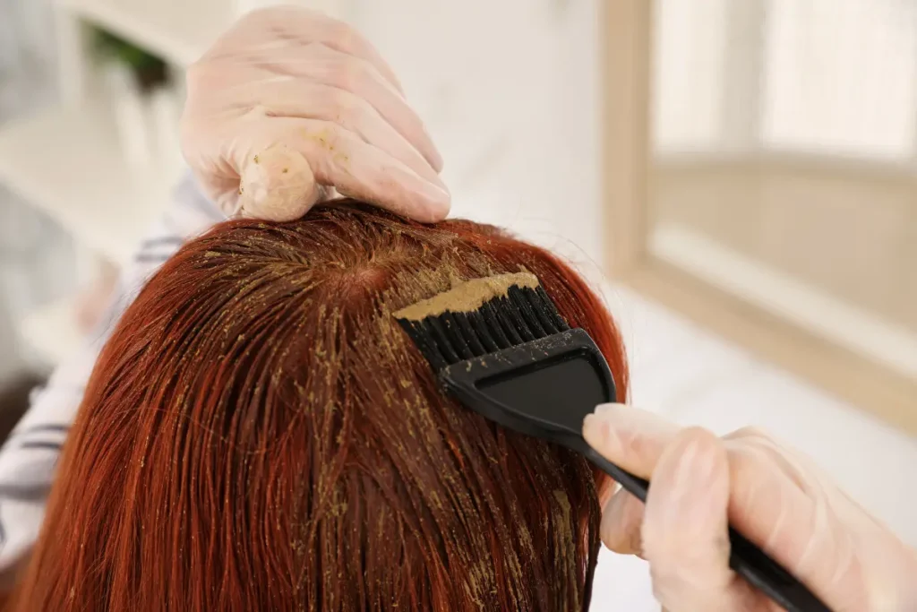 Mulher pintando o seu próprio cabelo