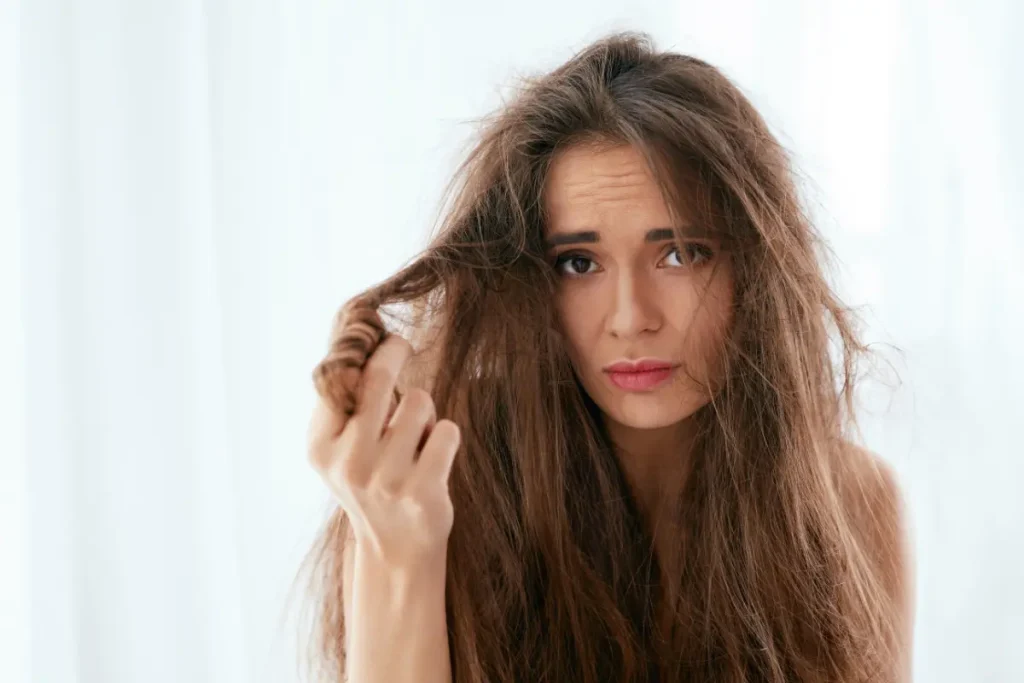 Mulher segurando o seu cabelo danificadoulher com o cabelo danificado