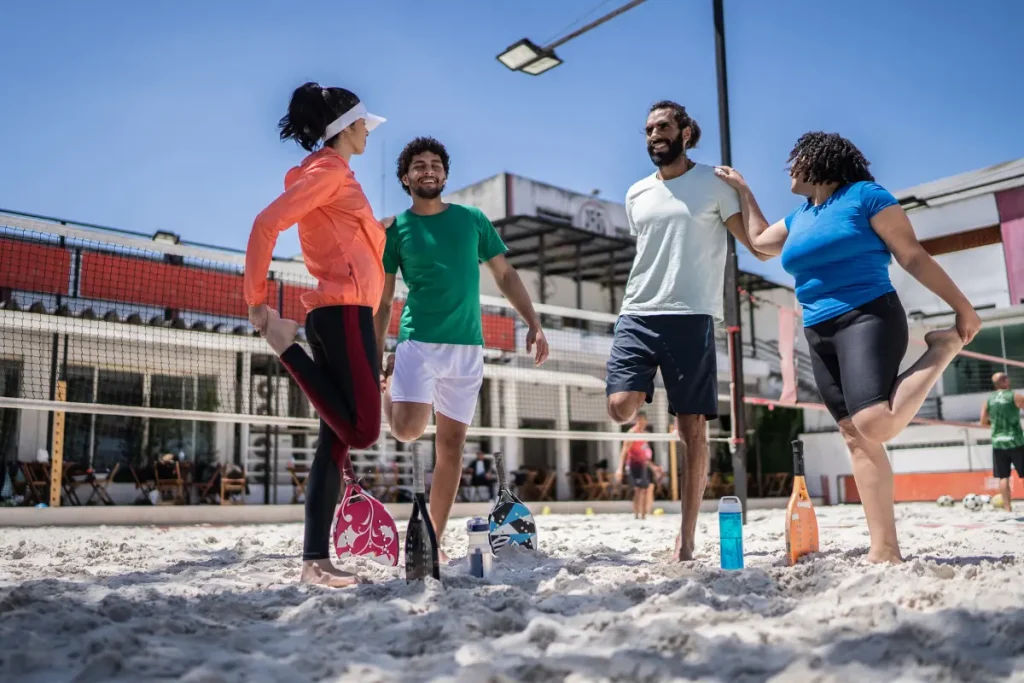 Pessoas se alongando para jogar Beach Tennis