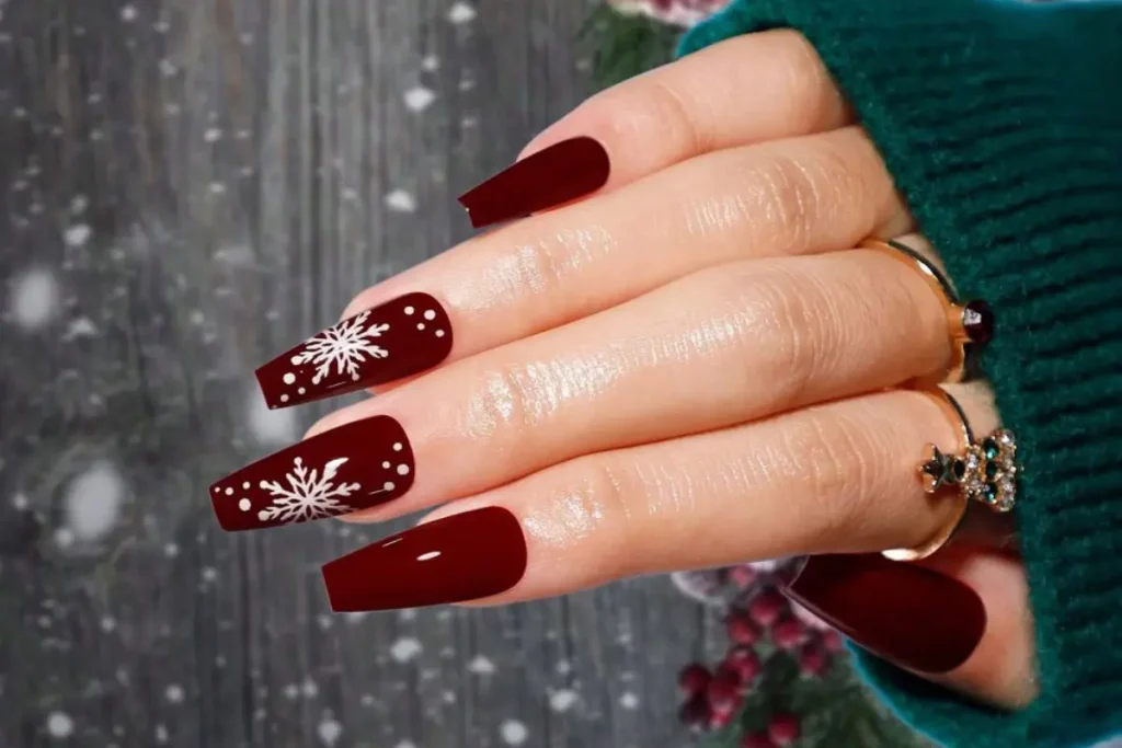 Unhas cor de vinho decoradas com flocos de neve