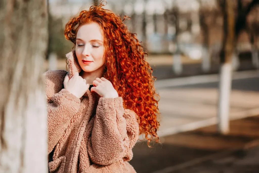 Mulher com cabelo cacheado ruivo