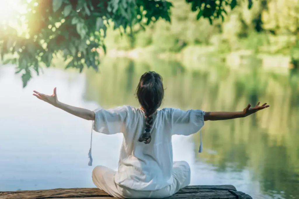 Mulher meditando na beira de um lago