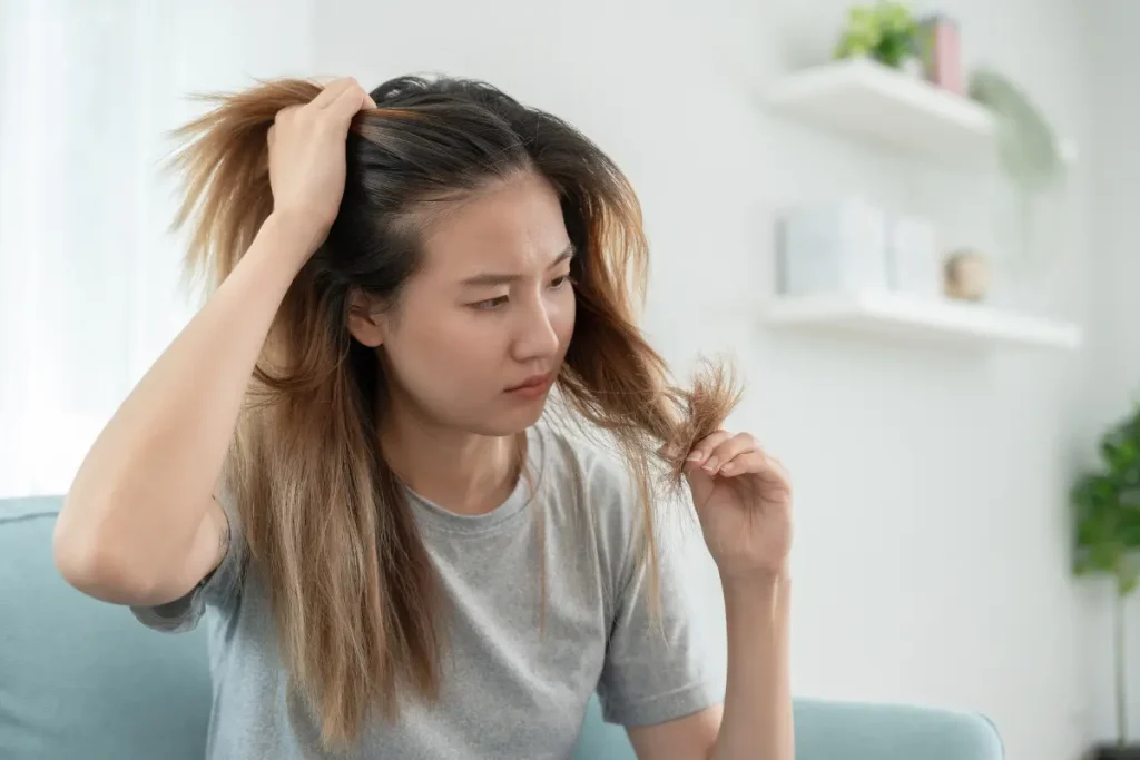 Mulher segurando e olhando para o seu cabelo