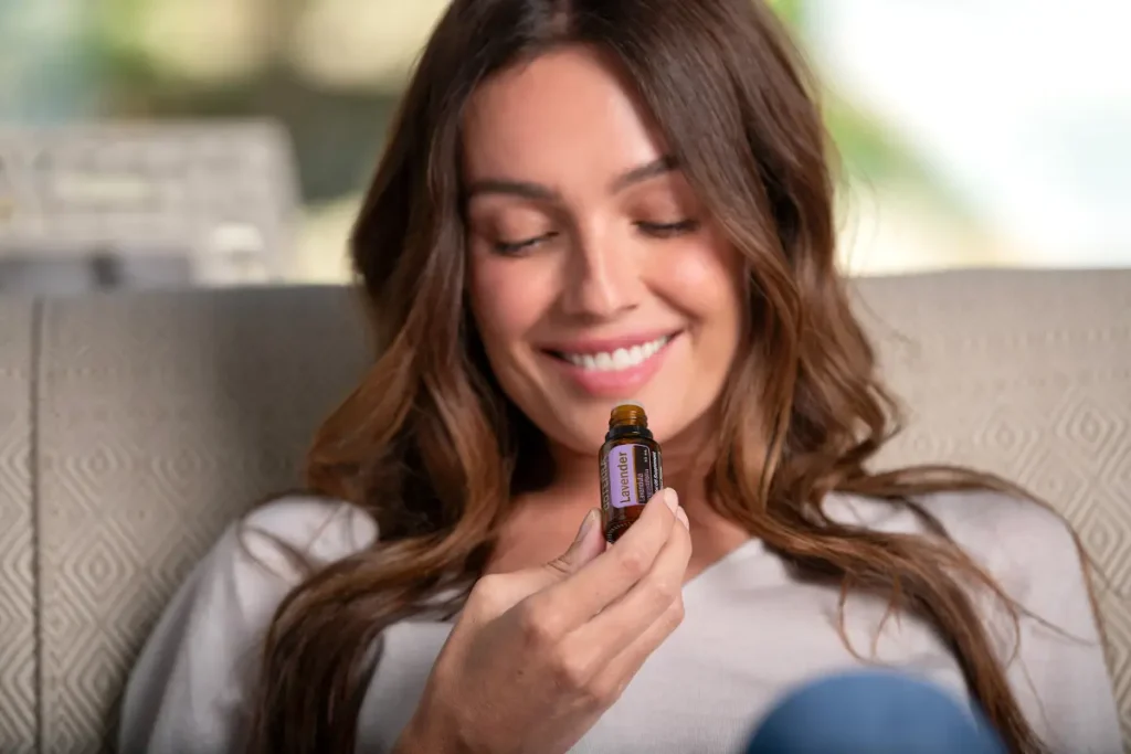 Mulher sorrindo segurando um frasco de óleo essencial