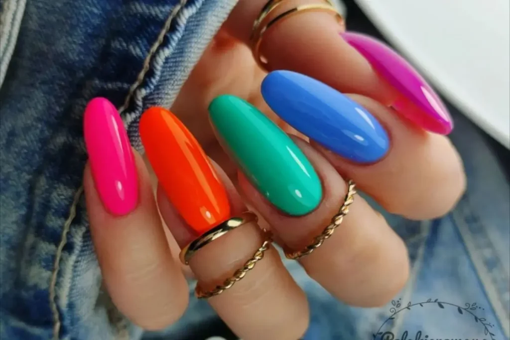 Unhas coloridas cor de rosa, laranja, verde e azul