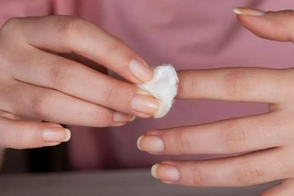 Mulher removendo o esmalte das unhas