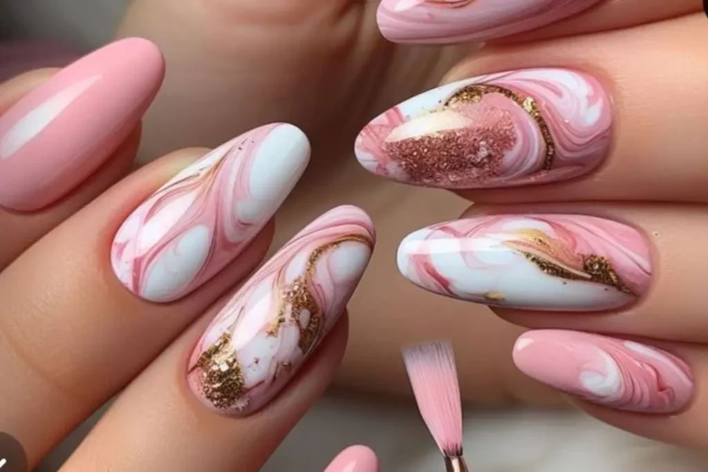 Unhas com efeito marmorizado rosa, branco e glitter dourado