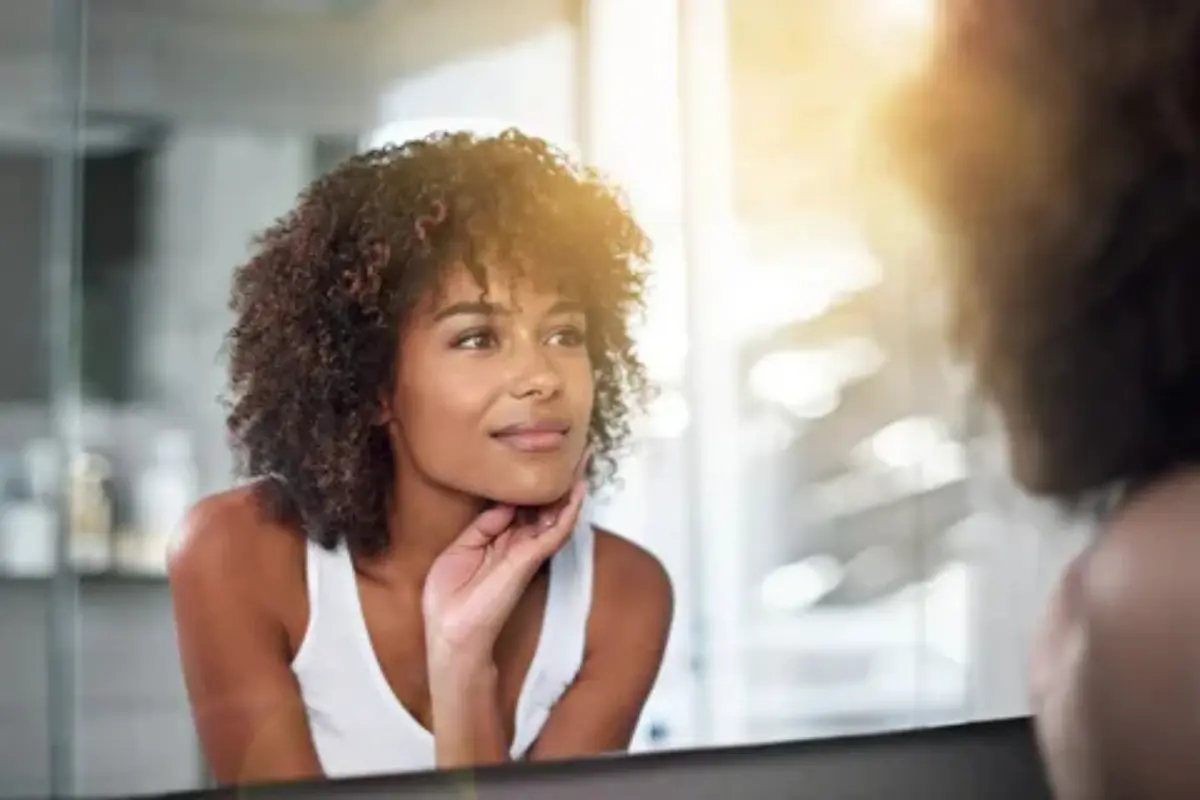 6 Benefícios de Autocuidado Para o Bem-Estar Feminino - Mulher se olhando no espelho