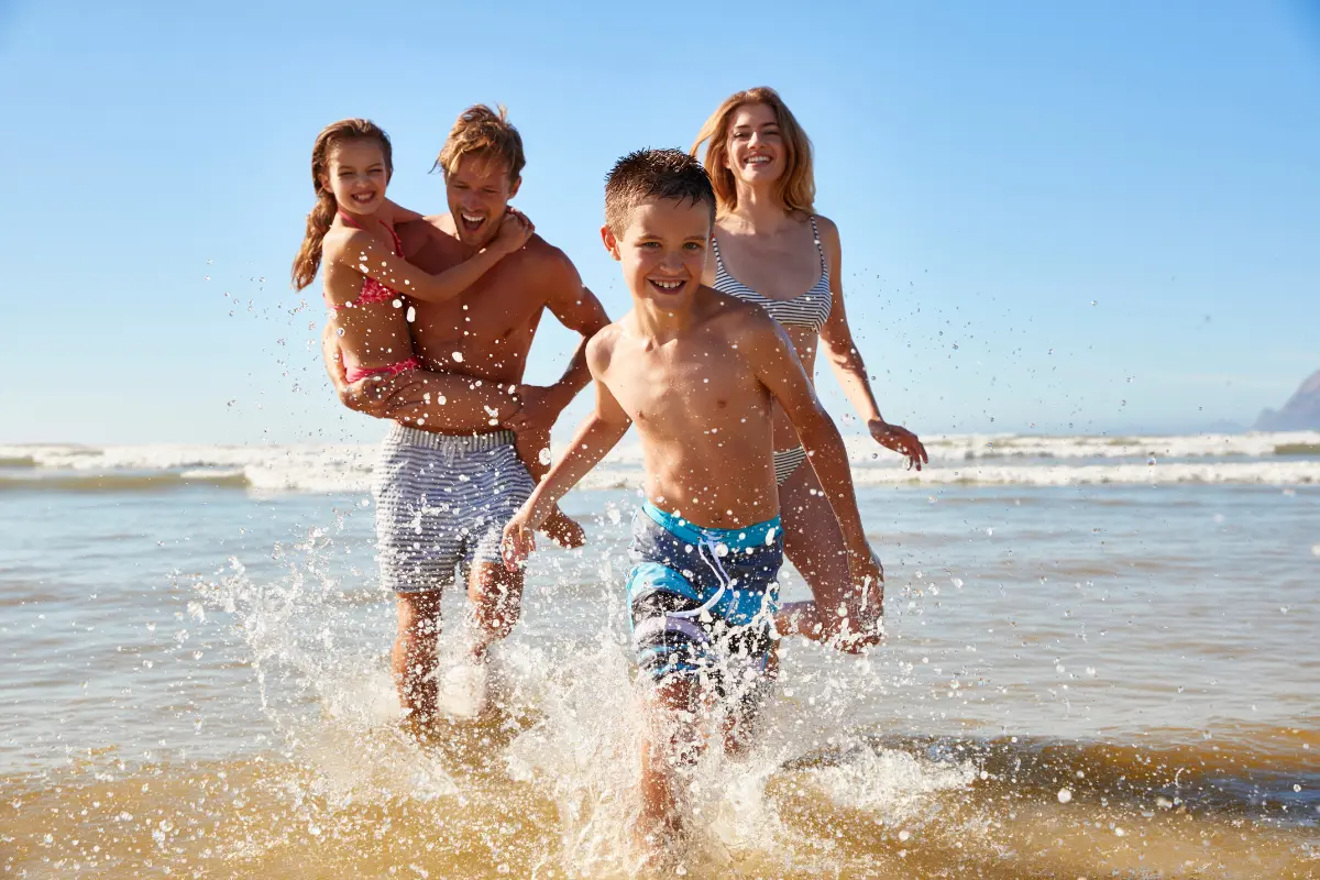 7 Benefícios do Contato com a Natureza Para o Bem-estar - Família se divertindo na praia