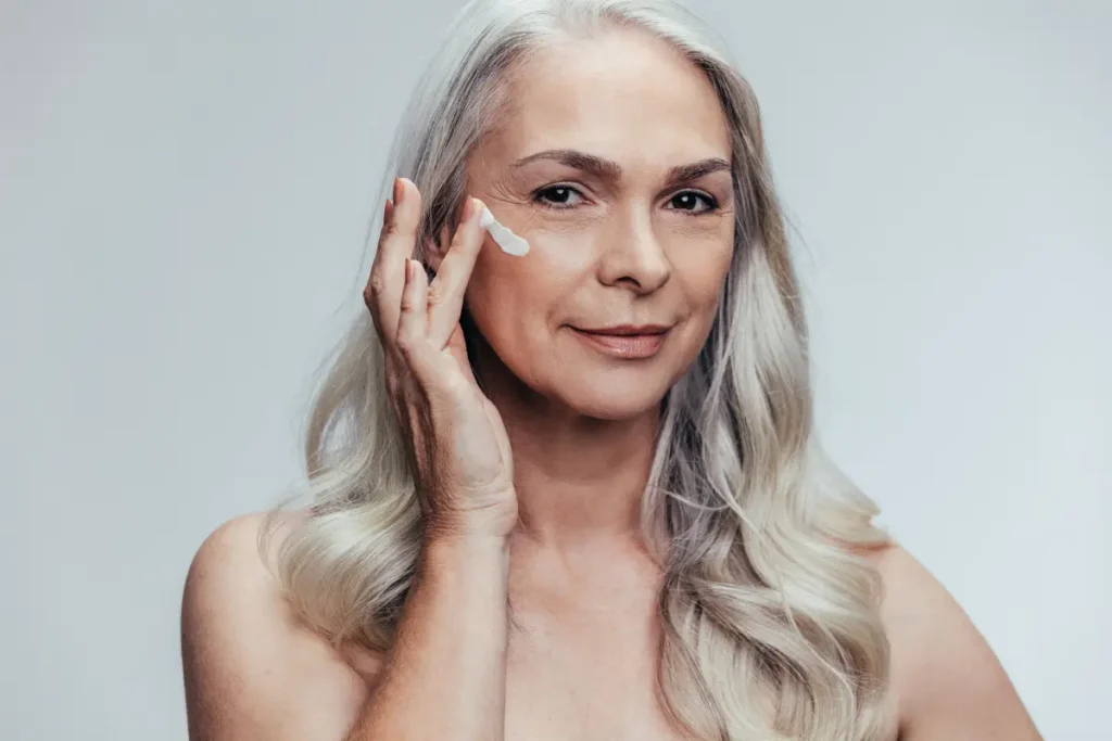 Mulher 50+ hidratando o rosto