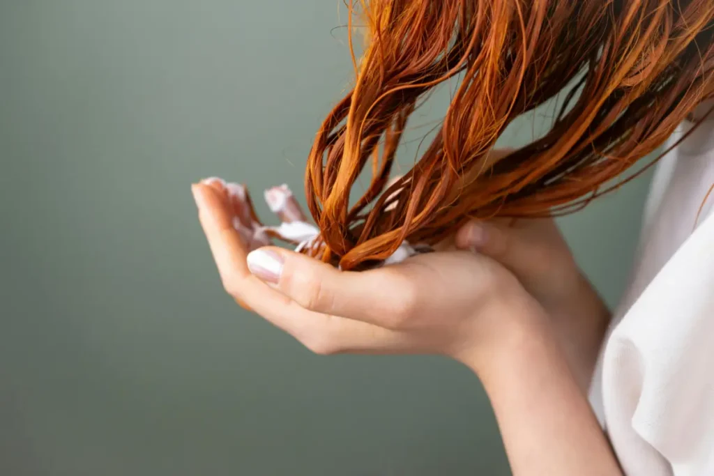 Mulher passando máscara capilar no cabelo