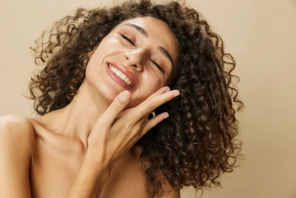 Mulher sorrindo com a mão no rosto