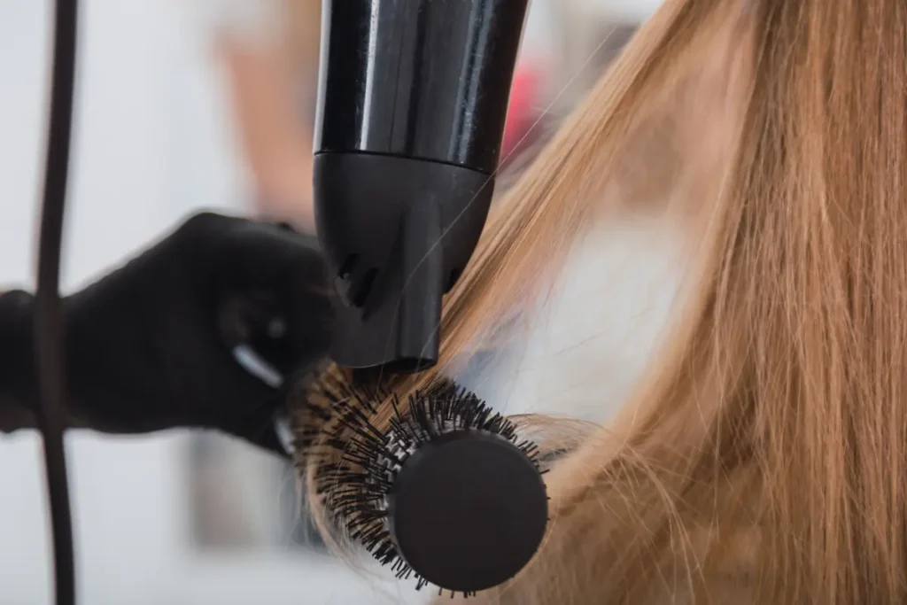 Profissional fazendo escova no cabelo da cliente