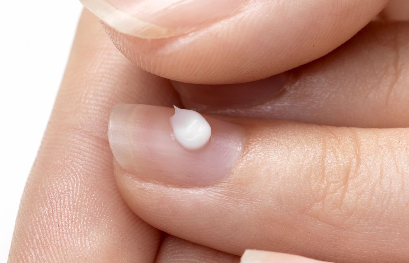 Mulher passando creme na unha