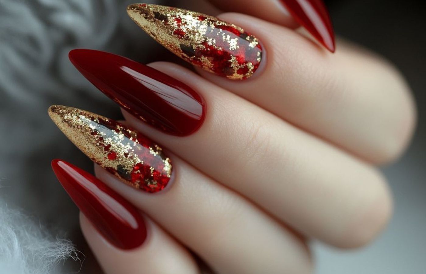 Unhas vermelhas decoradas com glitter dourado, preto e vermelho